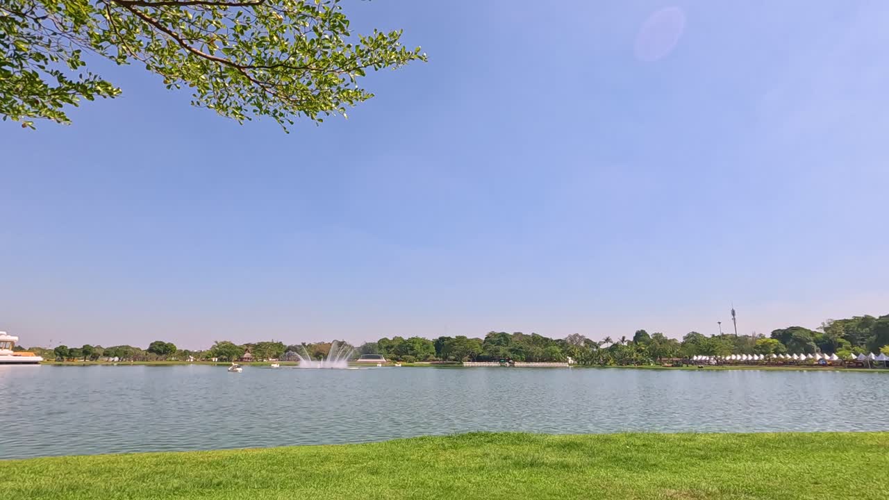 방의 라마 ix 공원 (rama ix park) 에서 은 하늘 아래 분수와 울창한 초록색이 있는 연못의 조용한 장면