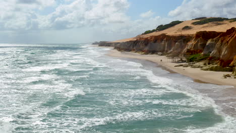 Vista-Aérea-De-Los-Acantilados-Con-Una-Pareja-Caminando-Por-La-Playa,-Morro-Branco,-Ceara,-Fortaleza.