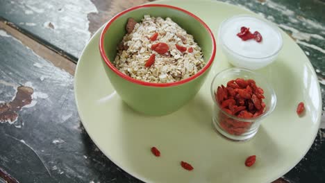 plate of breakfast cereal with raisin and yogurt on wooden table 4k