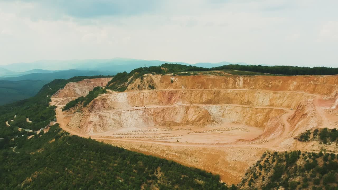 imágenes aéreas de movimiento rotatorio hacia atrás en movimiento desde la parte superior de la mina de la ladera