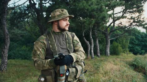 un hombre camuflado mira una brújula