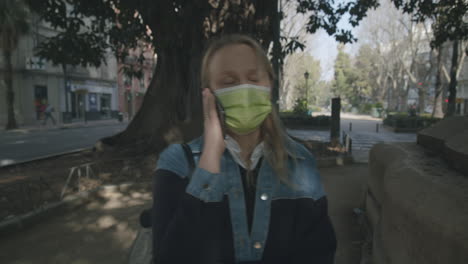 Woman-in-mask-having-a-phone-talk-outdoor