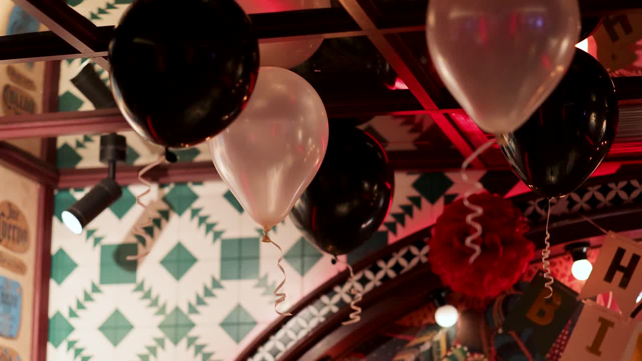 Colorful balloons adorn a restaurant in Bangkok, creating a lively and festive atmosphere with vibrant lighting and decor