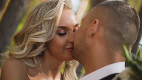 groom kisses beloved woman bride in sunny spring forest