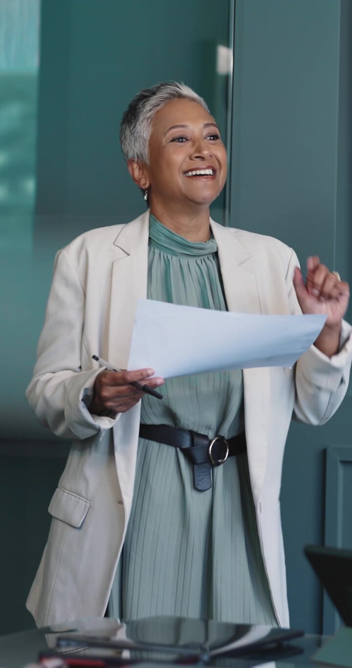 Professional Woman Presenting Documents in a Modern Office