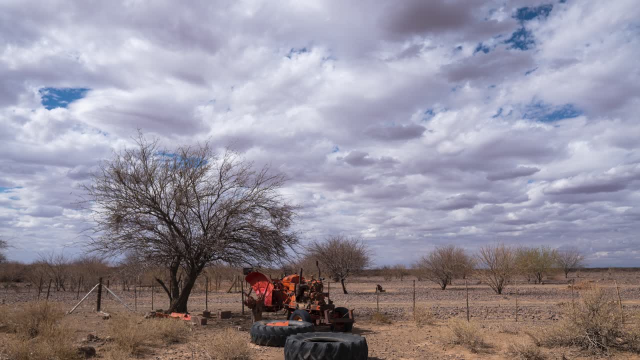 timelapse de un viejo tractor averiado con nubes formándose en el cielo
