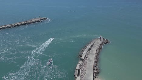 Luftaufnahme-Von-Booten,-Die-An-Einem-Sonnigen-Und-Atemberaubenden-Tag-Den-Hafen-Von-Ilha-Deserta-In-Faro-Verlassen