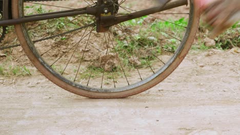 close up view of the legs of a man wearing old brown shoes while getting up on a bicycle before leaving in lang son city, vietnam with the view of agricultural field at daytime