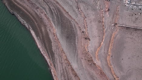 Drone-flying-over-dry-Sau-swamp-shores,-Catalonia-in-Spain