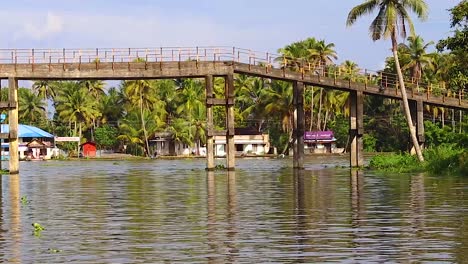 Traditionelle-Holzbrücke-Und-Weiße-Kirche-Am-Seerückstau-Am-Tag-Video-Aufgenommen-In-Alappuzha-Oder-Alleppey-Rückstau-Kerala-Indien