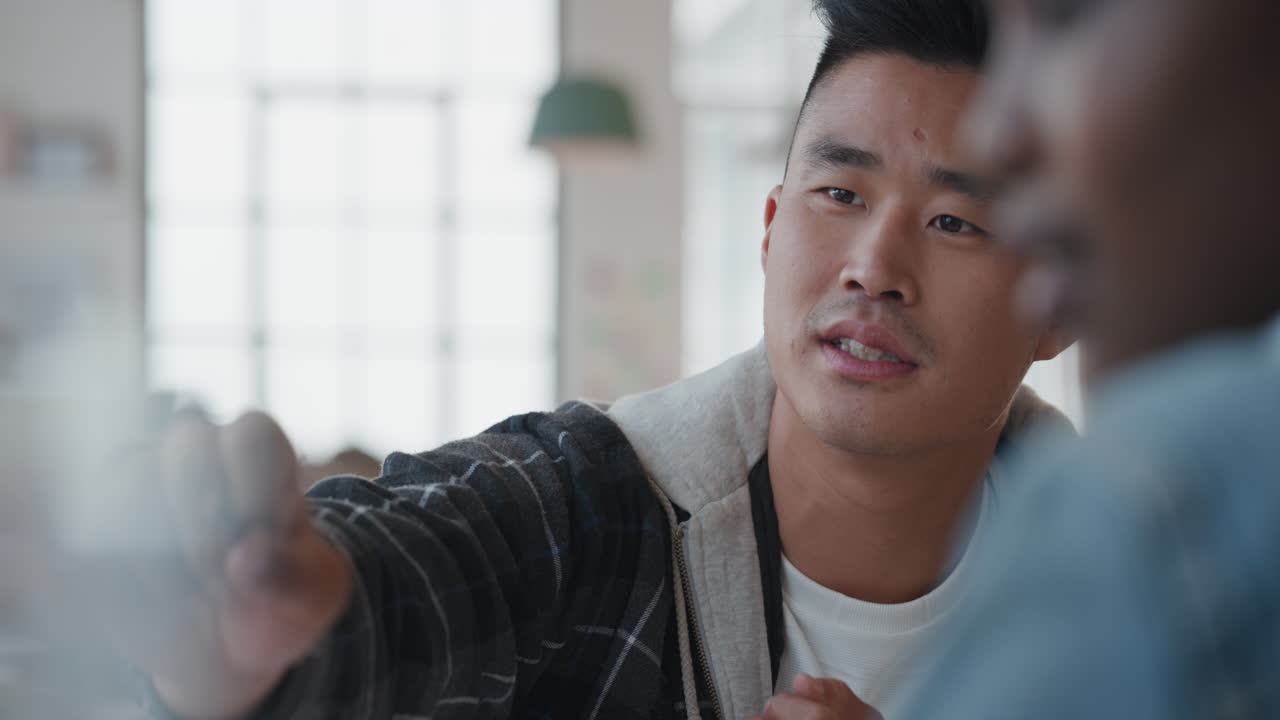 매력적인 젊은 아시아 남성 훈련 동료 화면을 가리키며 아이디어를 공유하고 직장에서 창의적인 팀워크를 즐기고