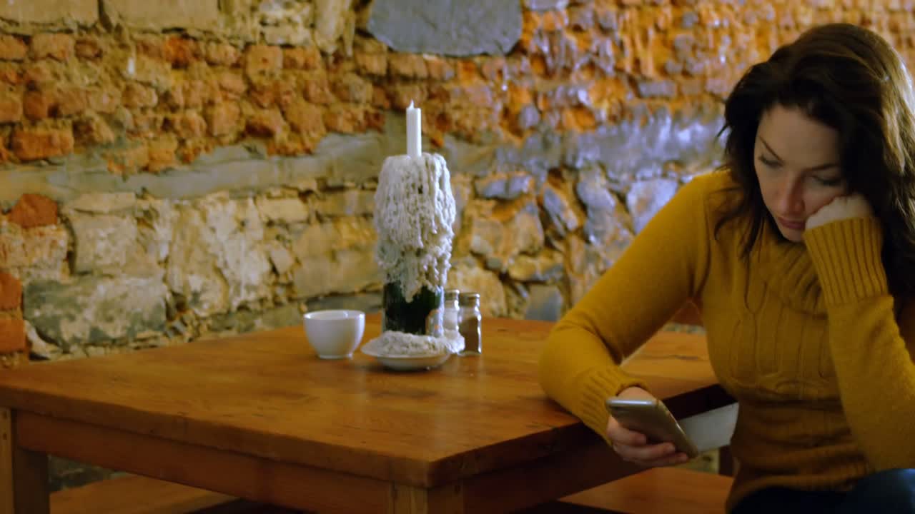 mujer usando teléfono móvil en un restaurante 4k