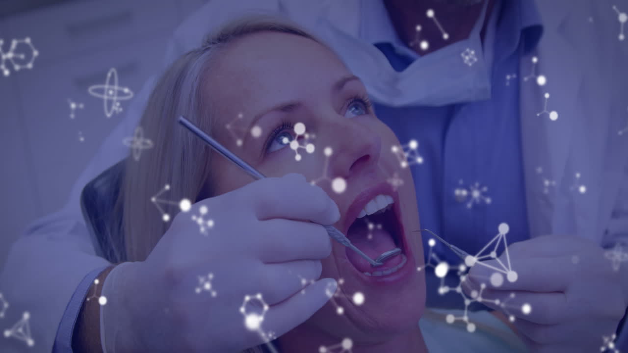 빛나는 분자 구조가 여성 환자를 치료하는 치과의사에게 움직이고 있습니다.