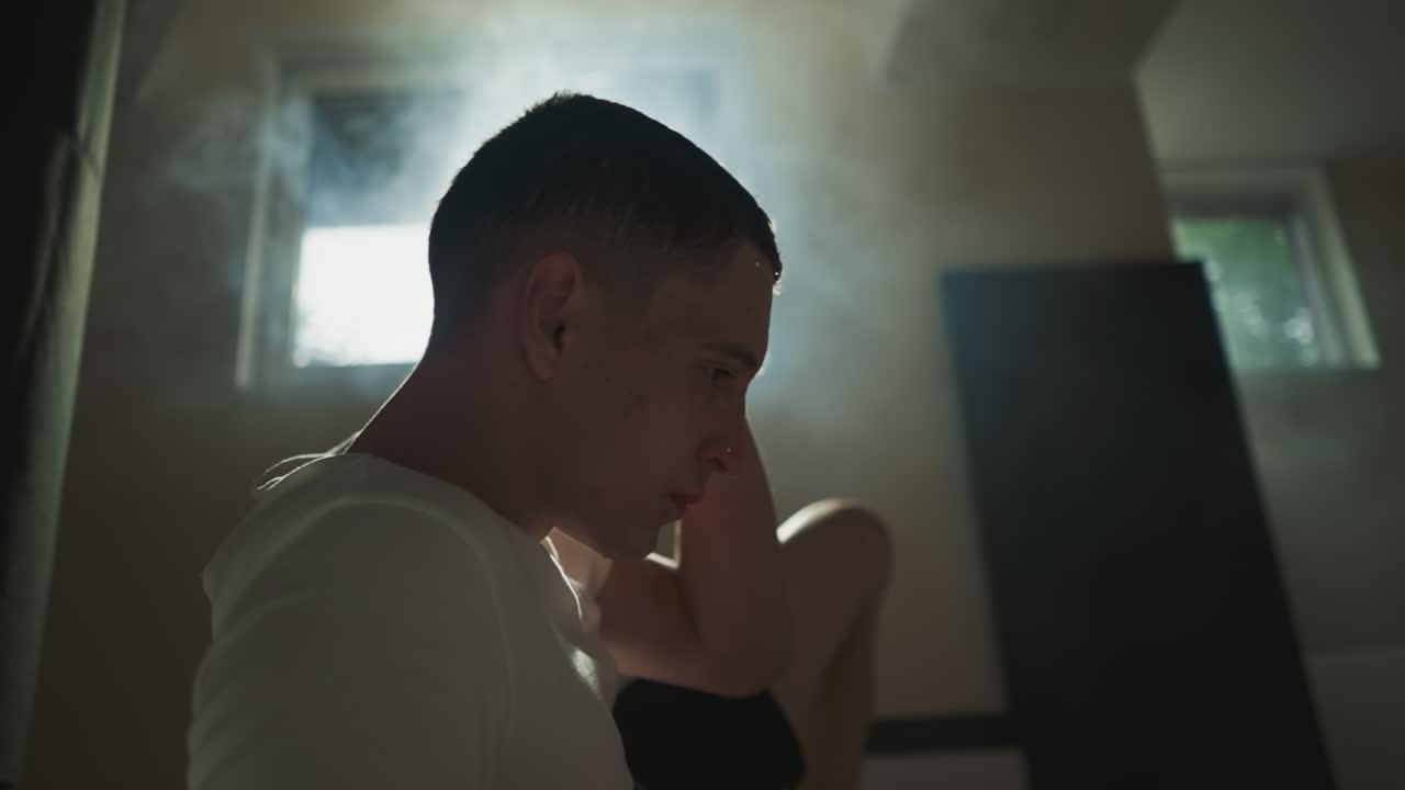 은 남자 권투 선수는 운동을위한 스포츠 클럽에서 손으로 습한 머리카락을 습니다. 격렬한 운동 후 긴장을 풀고, 운동 후 체력 향상 및 피로감을 느니다.