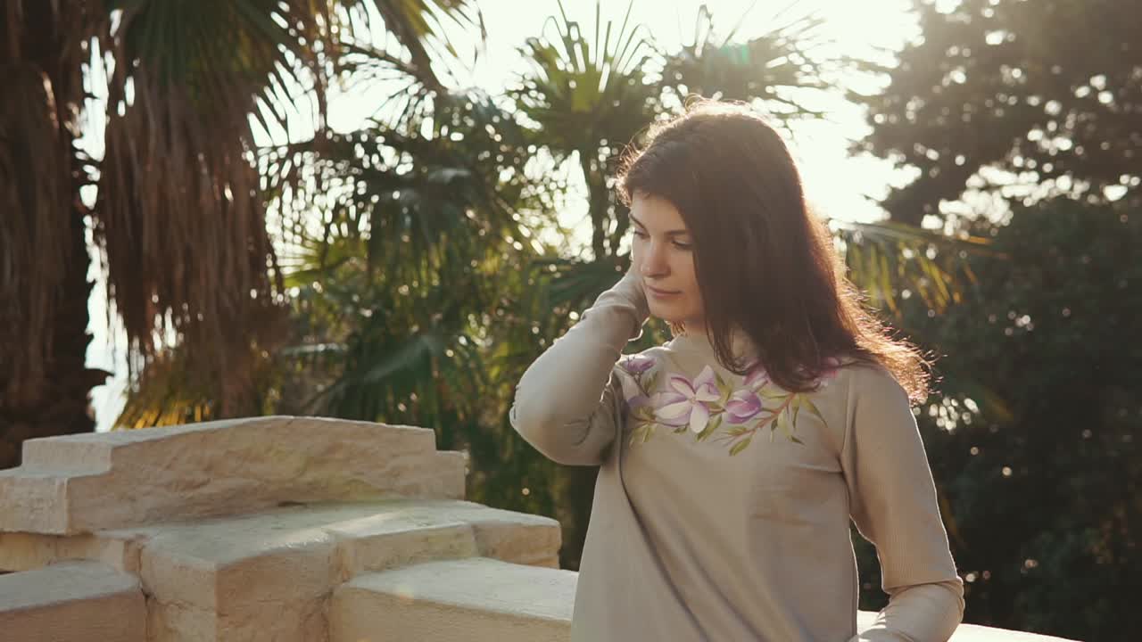 mujer con un suéter floral en un jardín