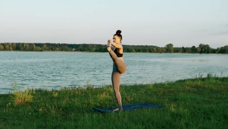 beautiful woman practicing yoga in morning. girl doing yoga moves on green grass