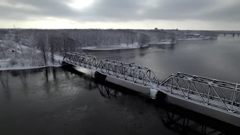 railway bridge going over a frozen river in winter