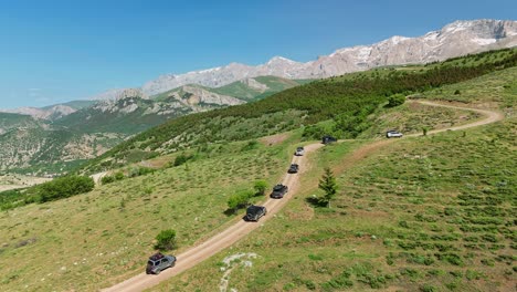 Scenic mountain trail drive with SUVs during sunny day, adventure mood