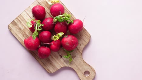 fresh red radishes on wooden cutting board