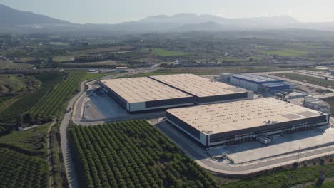 aerial-orbit-over-a-large-commercial-storage-warehouse-on-farmland-in-cartama-spain