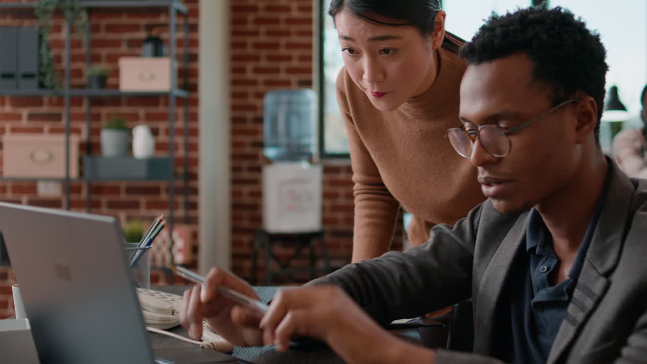 Person with impairment brainstorming ideas with aisan woman