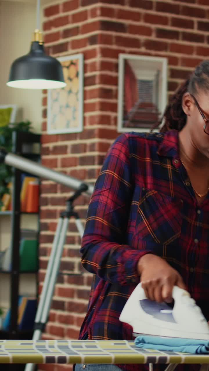 Video verticale: donna adulta che si diverte a fare il bucato a casa