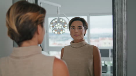 portrait woman looking mirror after beauty procedures in cosmetology clinic.