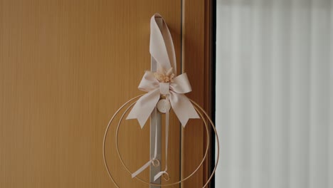 delicate white bow with a floral accent decorates a wooden door handle, adding a touch of elegance