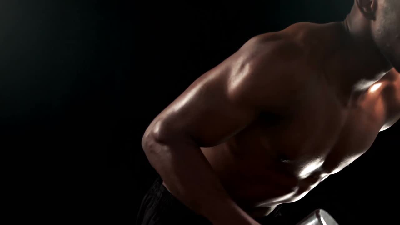 무거운 검은색 덤벨을 들어 올리는  ⁇ 한 남자