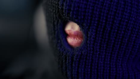 beautiful woman with red lips behind black ski mask – mysterious close-up