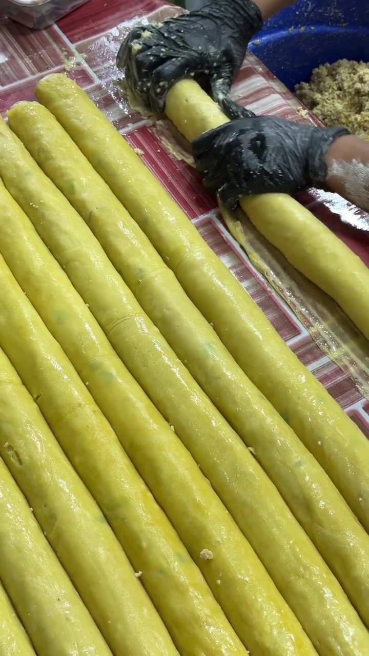 Persona che prepara involtini primavera tradizionali in una cucina professionale