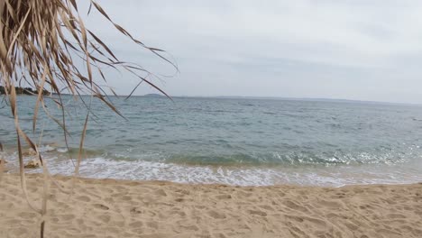 Brown-beach-sun-umbrellas-on-a-gentle-breeze-during-a-partly-sunny-summer-day