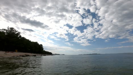 Textured-white-clouds-over-blue-sky-in-an-early-morning-over-wavy-water-surface