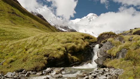 Arroyo-De-Cascada-Y-Montañas-Del-Himalaya-En-Nepal,-Paisaje-De-Cima-De-Montaña-Nevada-Y-Paisaje-De-Río-Que-Fluye-En-Terreno-De-Gran-Altitud-En-La-Región-De-Annapurna-En-El-Campamento-Base-De-Annapurna