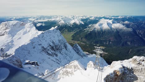 Vista-Sobre-Una-Barandilla-A-Las-Vías-De-Un-Teleférico-En-La-Cima-De-Una-Montaña-Nevada-En-Los-Alpes