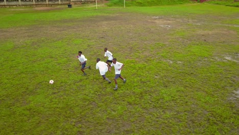 African Boys Play Football In Green Field In Tanzania