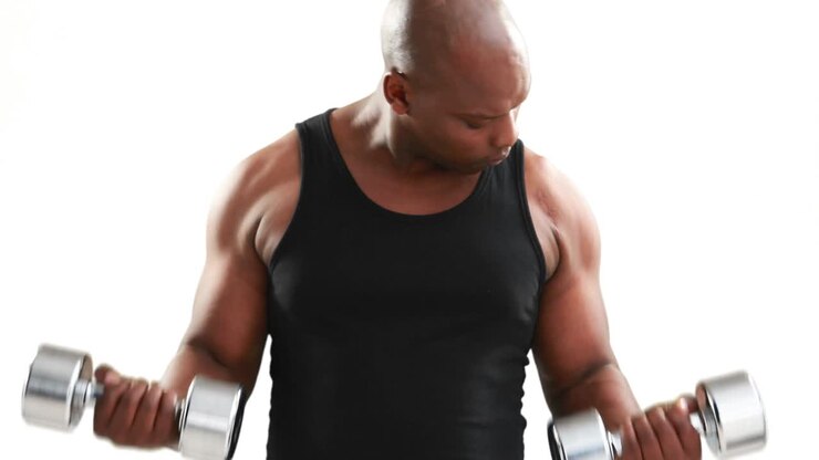 Serious muscular man lifting dumbbells