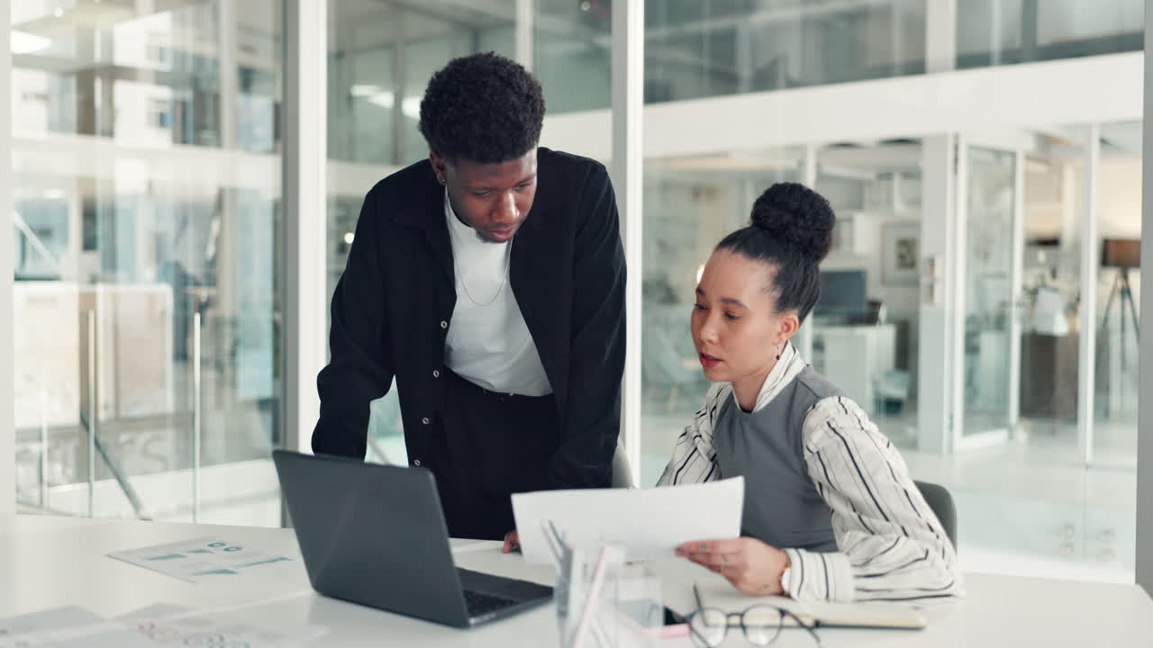 Two business professionals collaborating on a project in a modern office