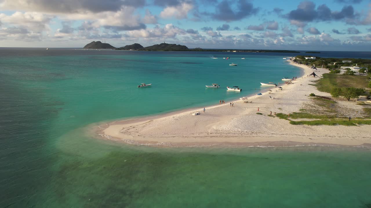 A serene aerial view of Punta Madrisky in Los Roques with turquoise waters and boats