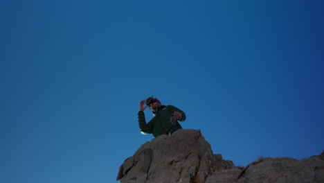 Drone-Pilot-Standing-On-The-Edge-Of-Rocky-Cliff-With-Drone-Goggles