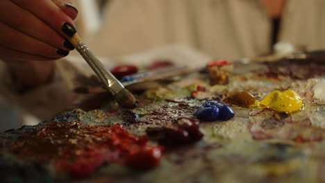 woman painter mixing oil paints in studio