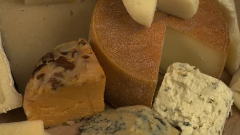 Close-up-rotating-cheese-platter,-variety-of-hard-and-soft-cheeses