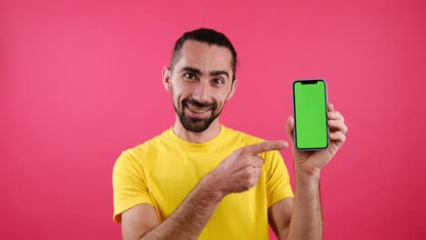 hombre apuntando con el dedo al teléfono móvil con pantalla verde