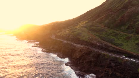 toma de drones de la carretera hawaiana en un acantilado al lado del océano durante el amanecer