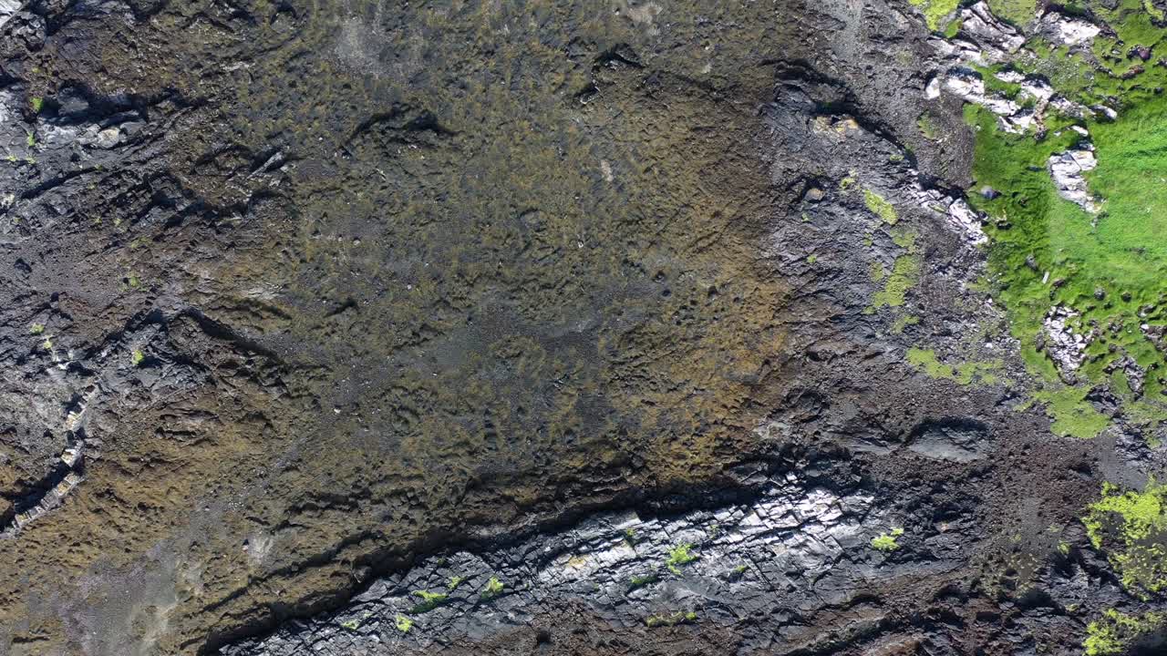 toma aérea mirando hacia abajo sobre la línea de la costa escocesa durante la marea baja