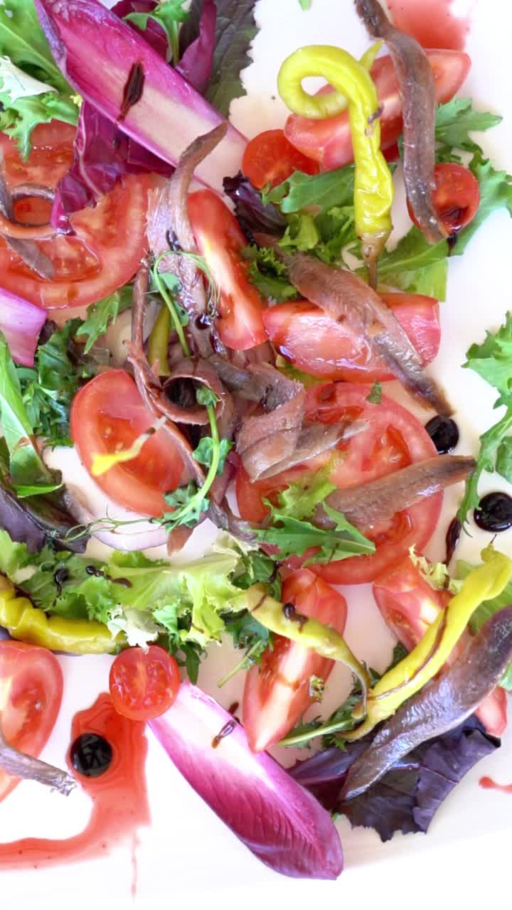 Un piatto di cibo con salsa rossa e diverse verdure, tra cui pomodori