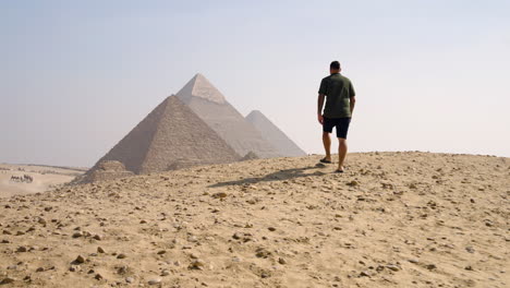 a man heading toward the pyramids, taking in the sights of the giza plateau near cairo, egypt - tracking shot