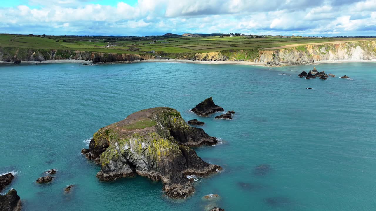 paisaje marítimo estático drones pequeñas islas y mares azules profundos playas desiertas y acantilados marinos con nubes en un día de primavera ar la costa de waterford en irlanda estableciendo tiro