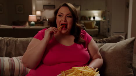 woman eating french fries on a sofa