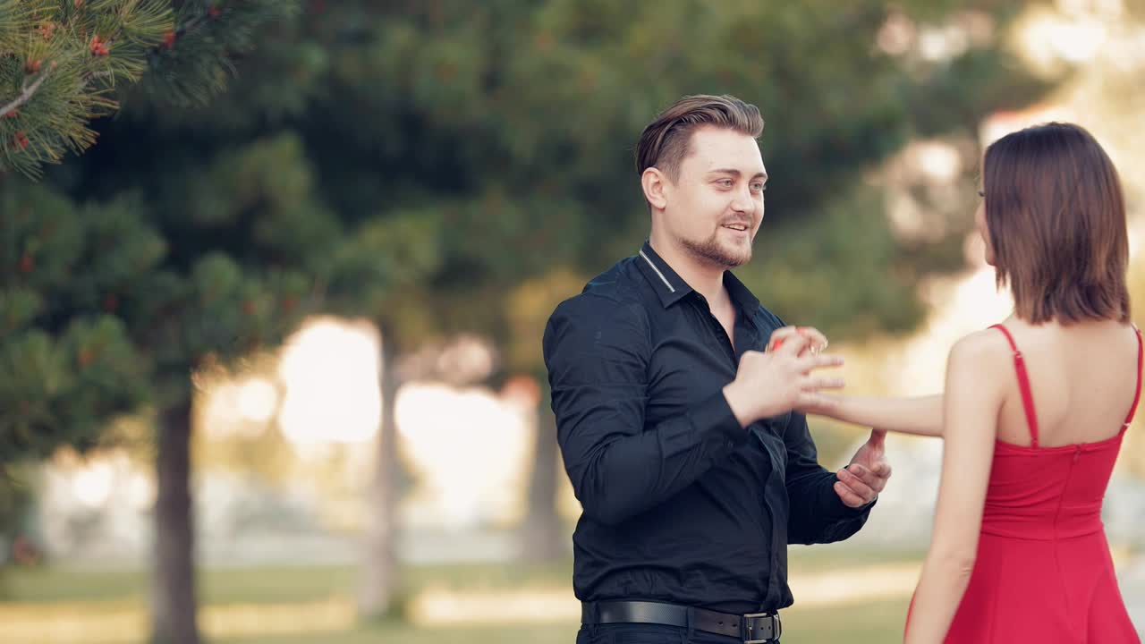 un joven abraza a su amada en un parque de verano al atardecer.